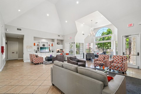 A spacious living room with a grey sofa and a chandelier.