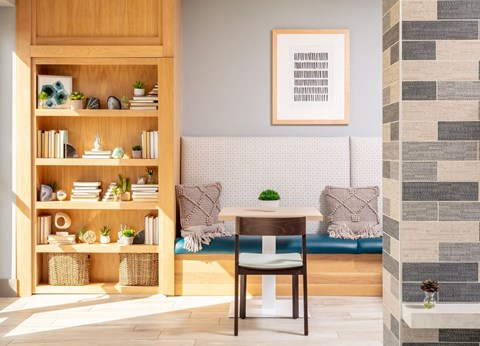 a room with a table and a couch in the background and a bookcase in the foreground