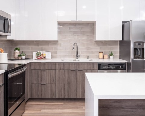 a kitchen with white countertops and wooden cabinets