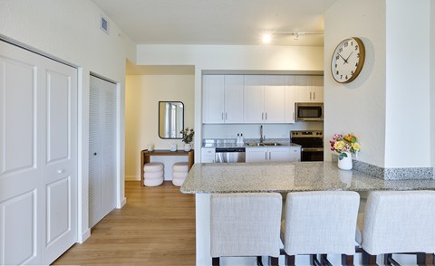 A kitchen with a table and chairs in front of it.