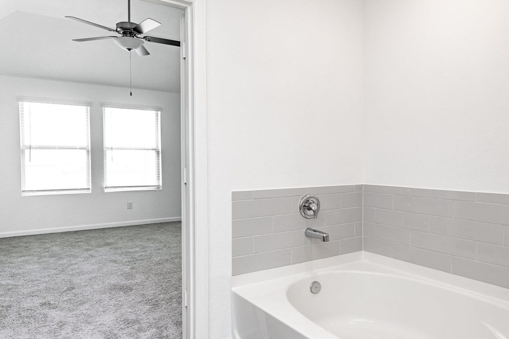 a white bathroom with a white ceiling fan
