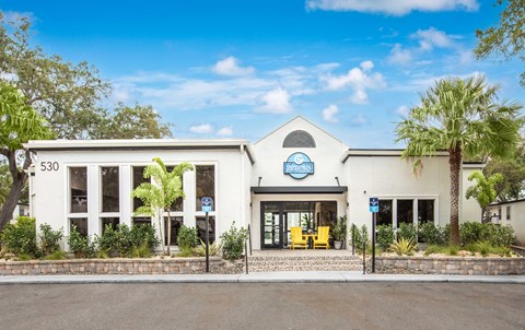 A white building with a blue sign that reads "Pet Friendly" is surrounded by greenery.