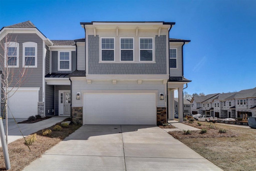 a house with a white garage door in front of a blue sky