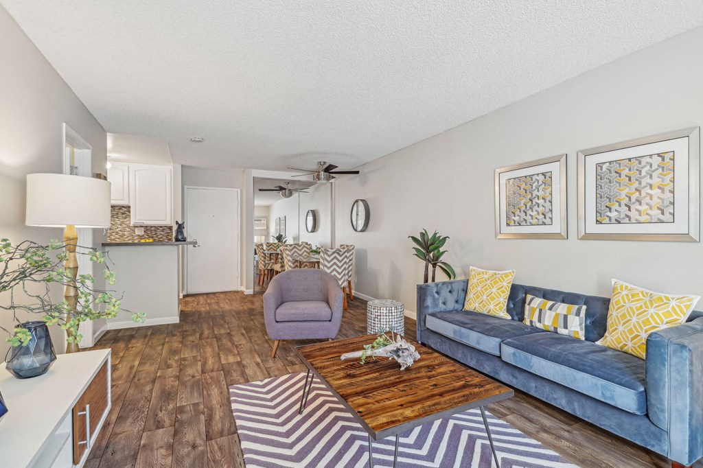 A living room with a blue couch and a wooden coffee table.