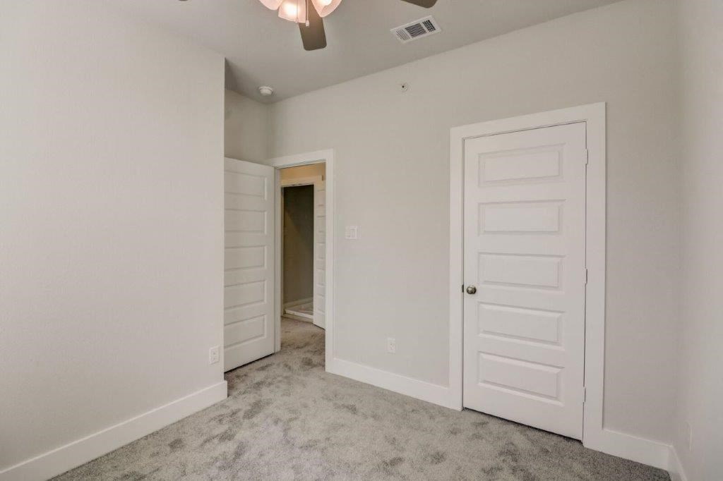 a bedroom with a white door and a closet