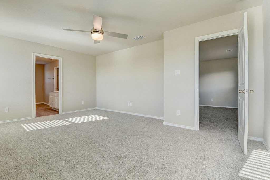 an empty living room with a ceiling fan