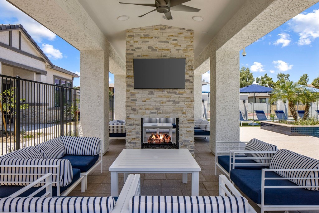 A patio with a fireplace and a television mounted on the wall.
