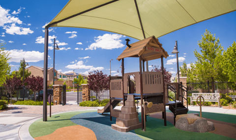 Skye Canyon, NV Apartments - Banyan Brighton - Playground Under A Canopy With A Bench Surrounded By Trees.