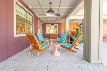 a patio with chairs and a table in front of a building - Photo Gallery 26