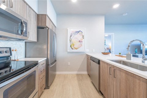a modern kitchen with stainless steel appliances and wooden cabinets