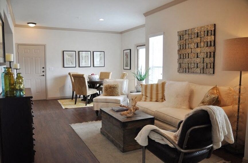 Living room with wood flooring and couches and windows with blinds