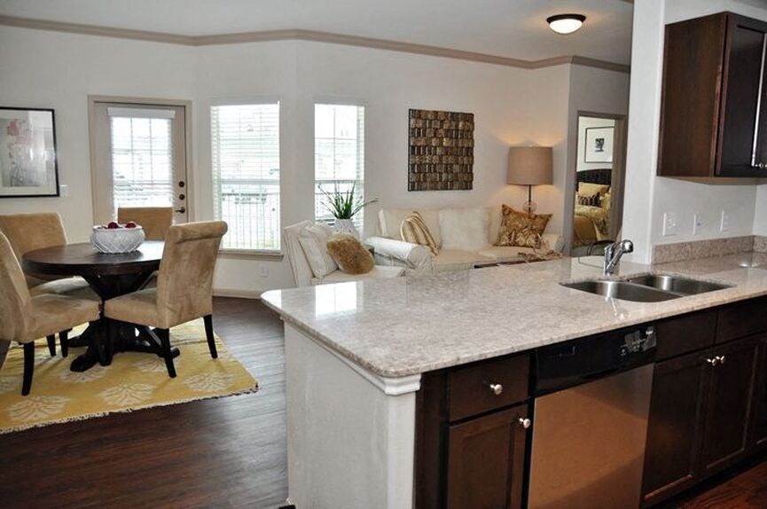living room with wood floor and windows and kitchen with wood cabinets