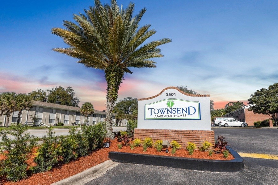 an exterior view of the townsend sign in front of a building with palm trees