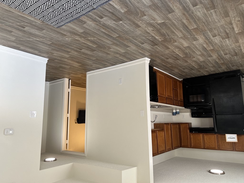 a view of a kitchen and a living room with a wood ceiling