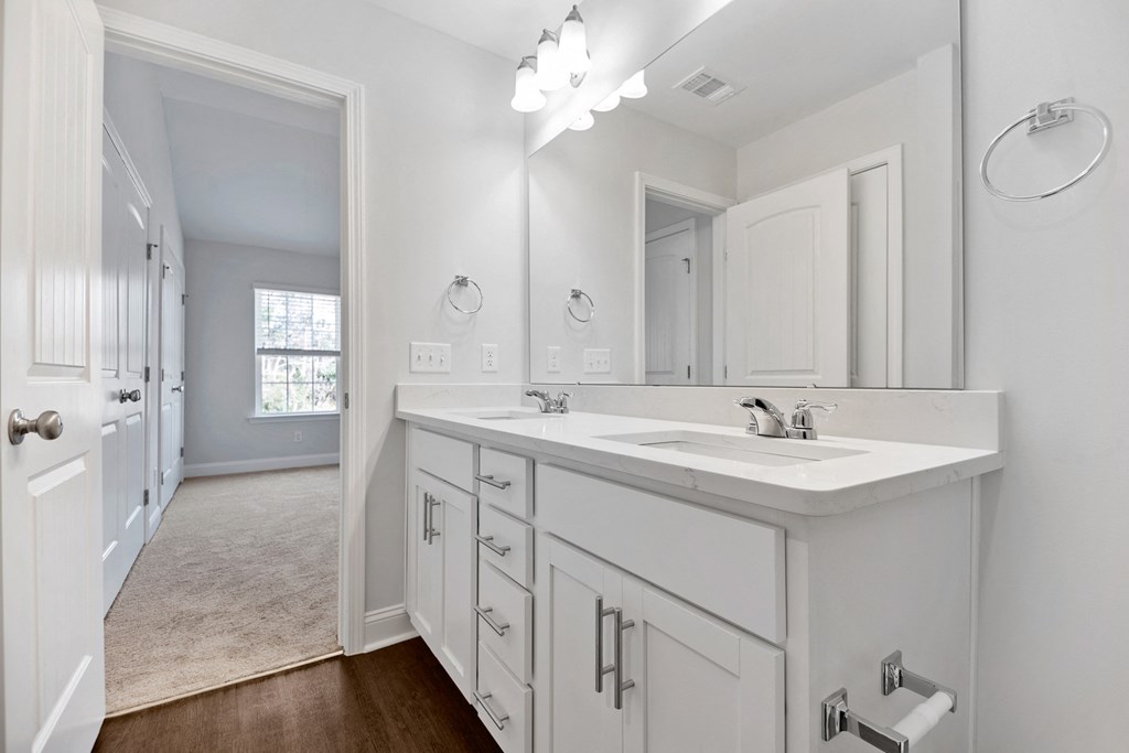 a white bathroom with a large mirror and a sink