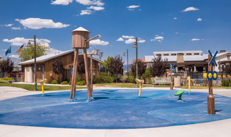a childrens playground with a water feature in front of a building