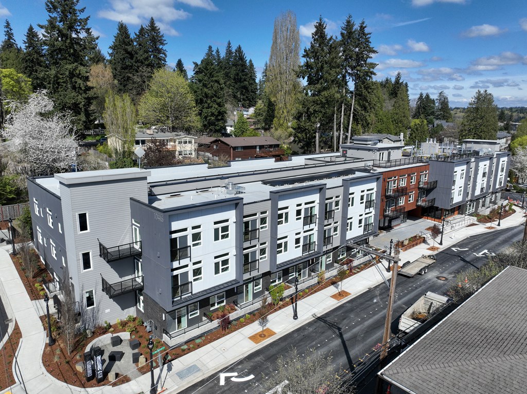 an aerial view of an apartment complex with trees in the background