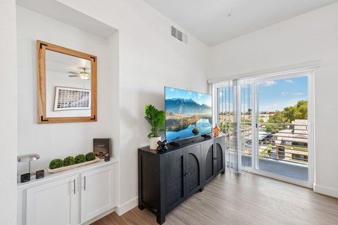 A living room with a flat screen TV and a large mirror on the wall.