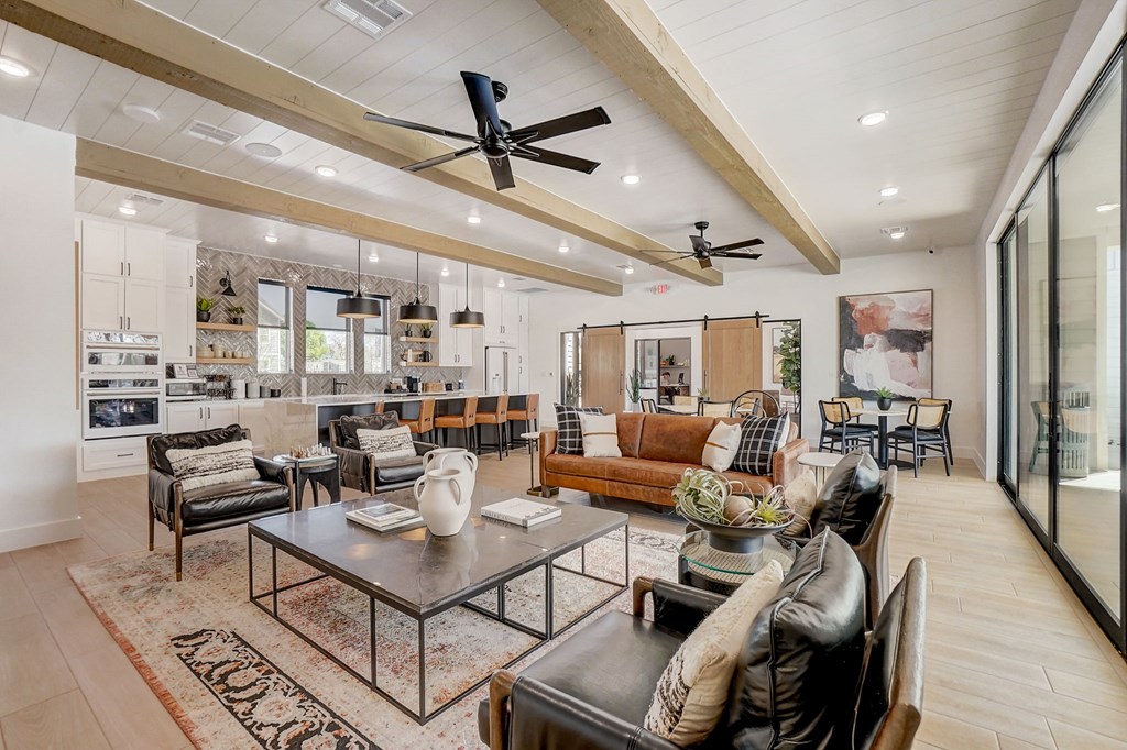 a living room with couches and chairs and a kitchen