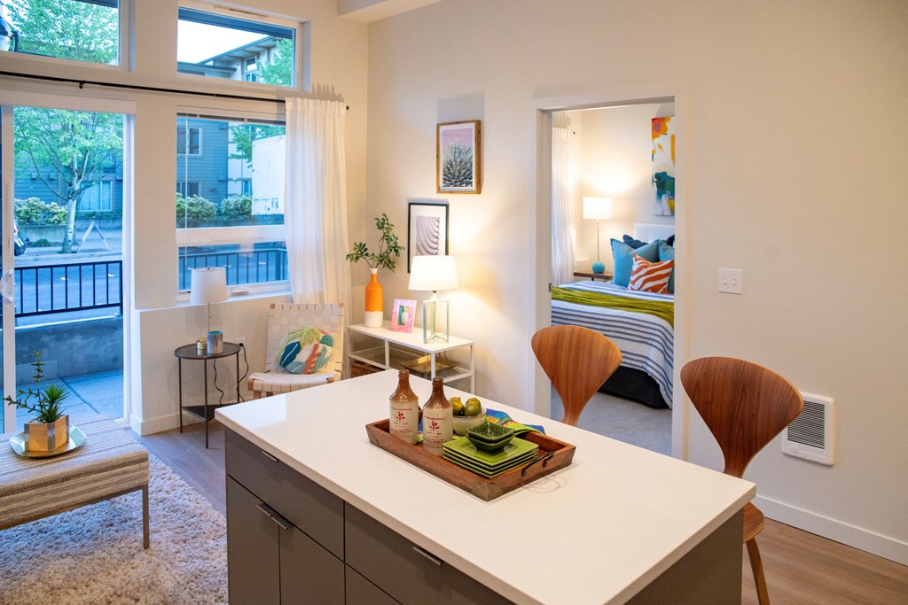 an open kitchen with a view of a living room and a bedroom