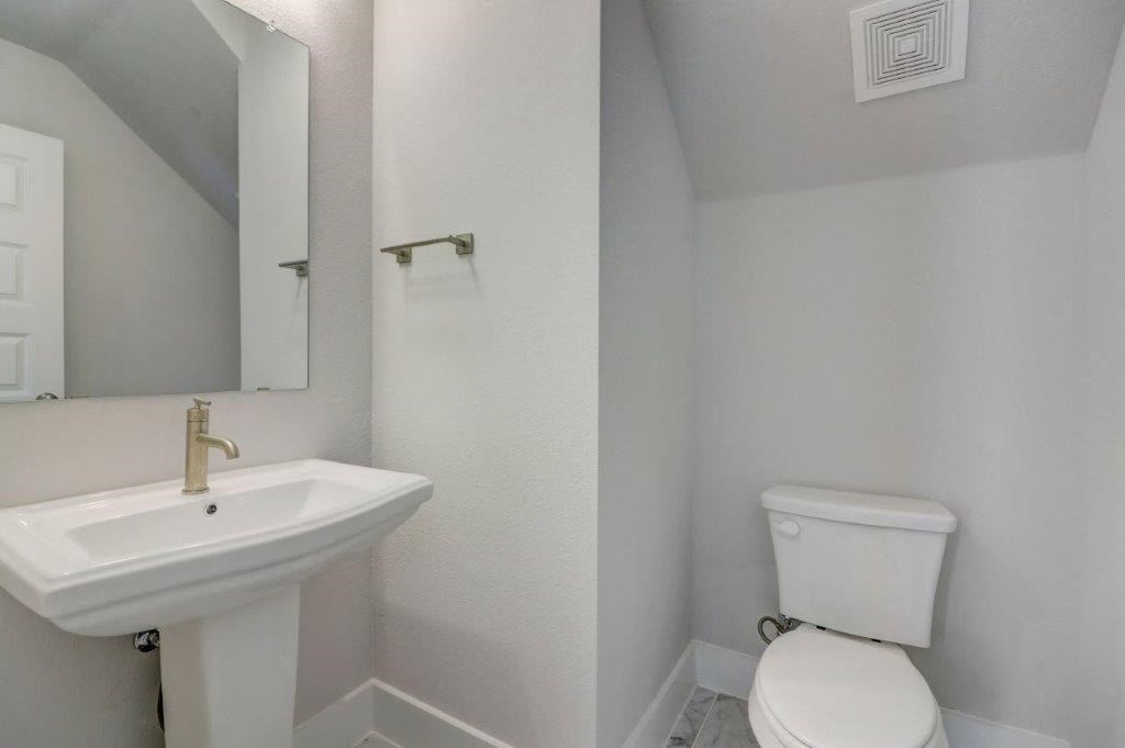 a white bathroom with a sink and a toilet