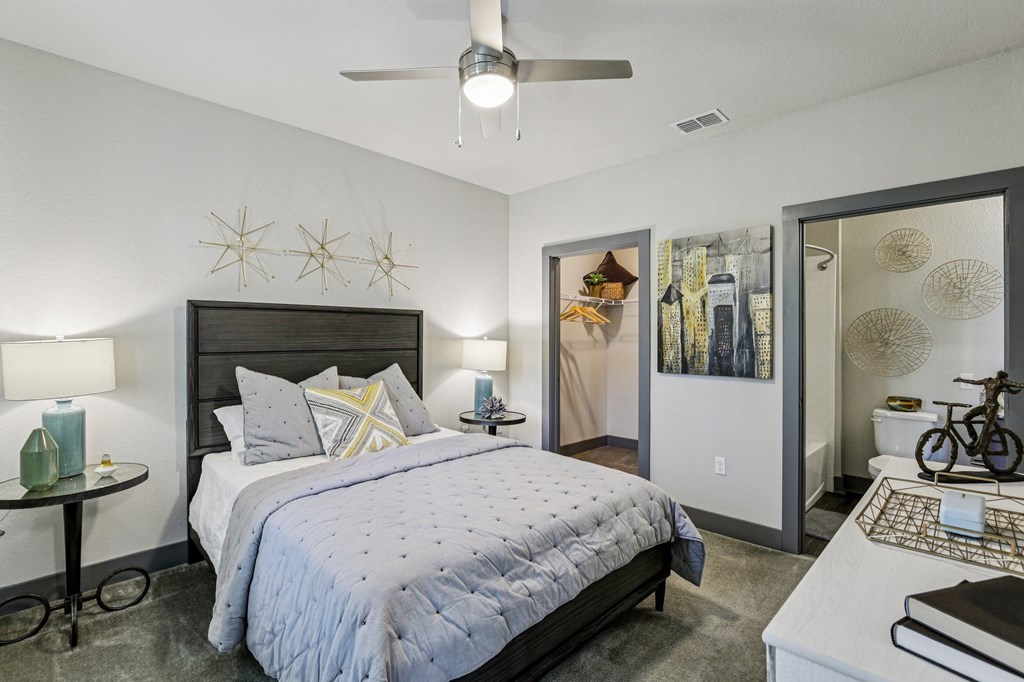 Bright bedroom with large windows, ceiling fan, and simple decor at Lotus at Starkey Ranch in Odessa, Florida.
