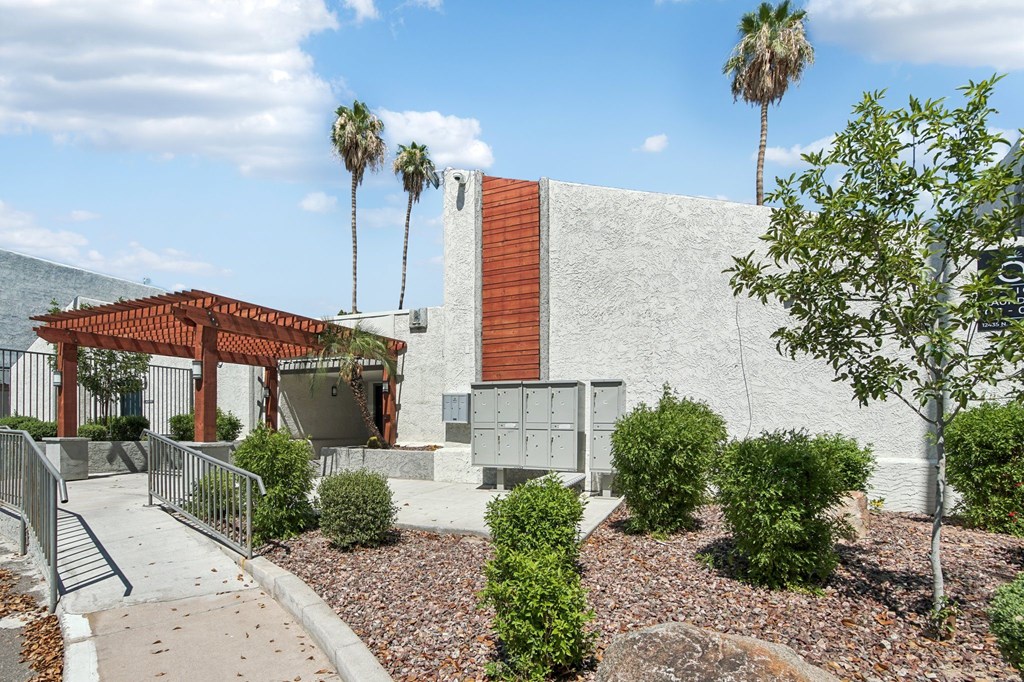 A building with a red roof and a white wall with a mountain in the background.