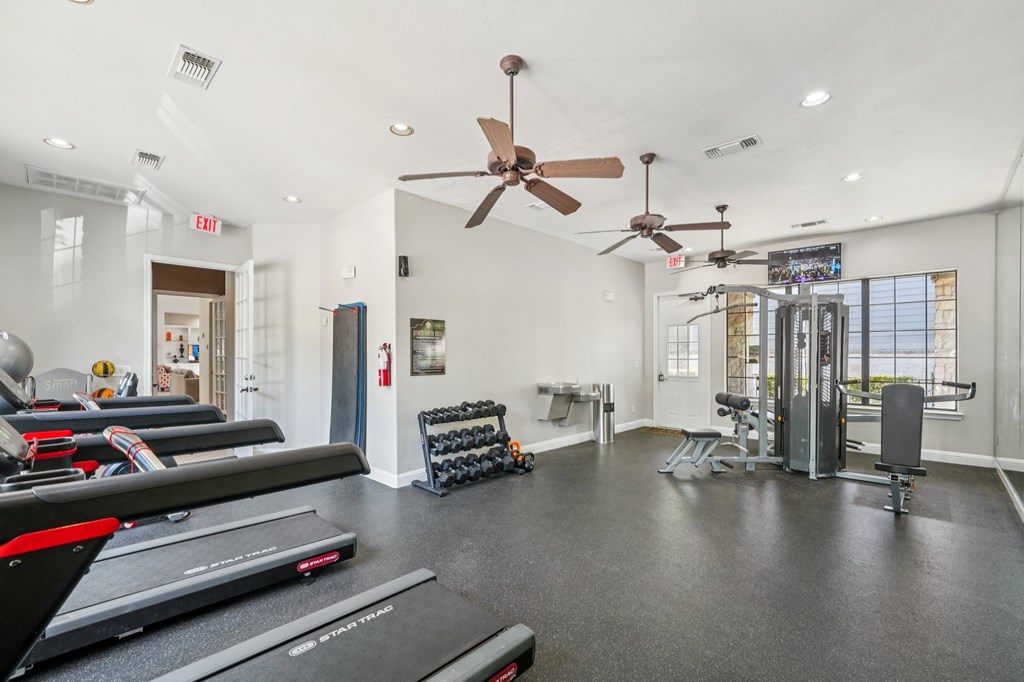 A spacious gym with treadmills, weights, and exercise equipment.