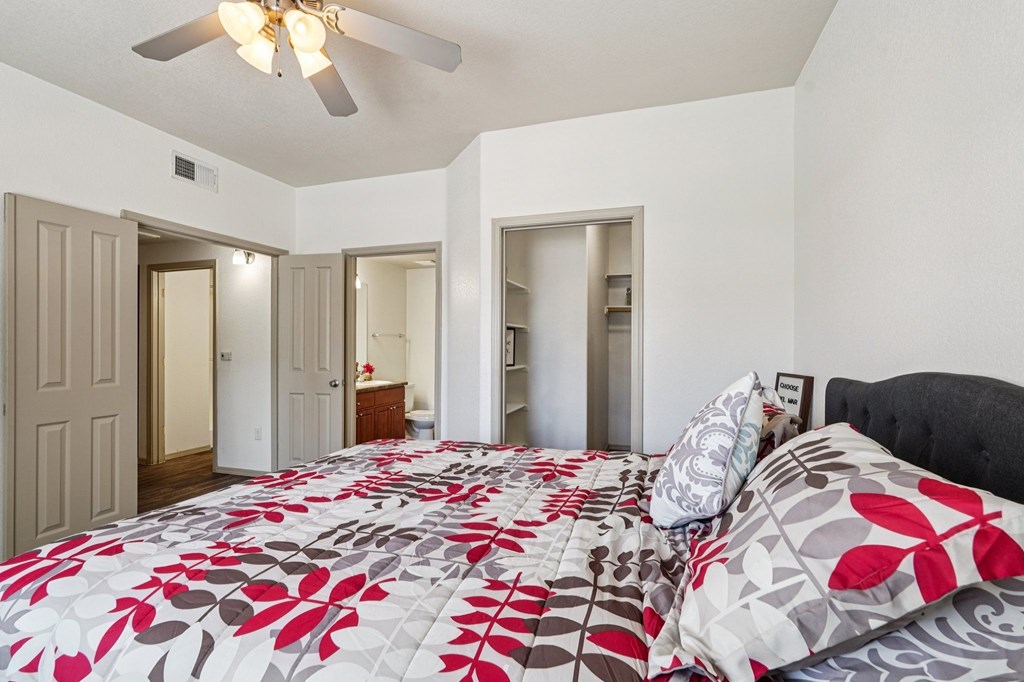 A bedroom with a large bed and a ceiling fan.