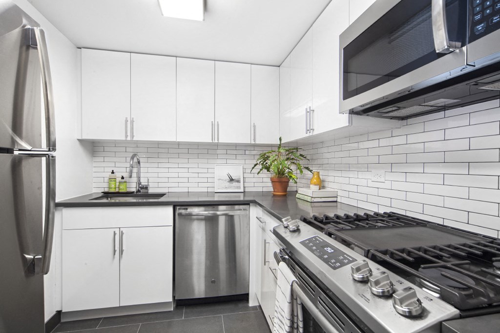 a white kitchen with stainless steel appliances and white cabinets