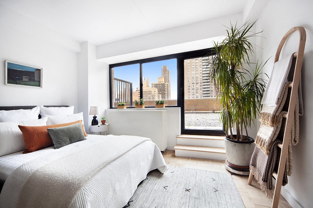 a bedroom with a bed and a large window