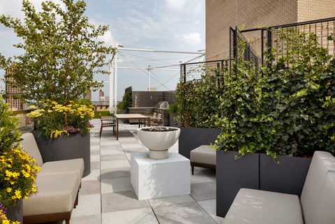a terrace with couches and plants and a fountain