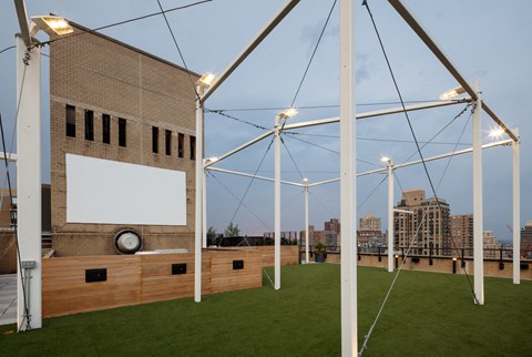 a roof top lawn with grass and a building with lights