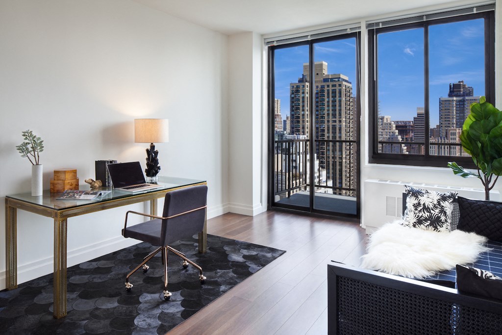a home office with a desk and a view of the city
