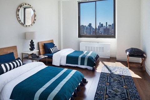 Luxury Apartments In Upper East Side NYC - The Wimbledon - Spacious Bedroom With Two Beds, Wood Flooring, A/C, And Window For Natural Sunlight