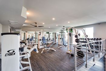 A gym with a variety of equipment including a Cybex weight machine.