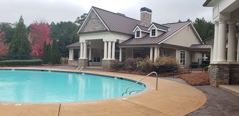 A house with a pool in front of it.