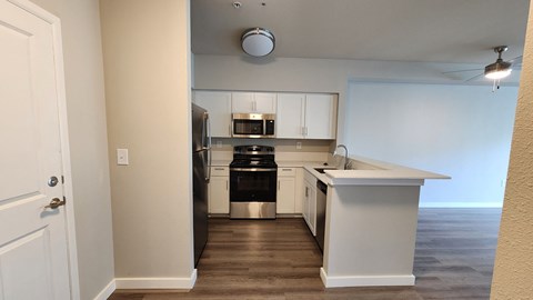 A kitchen with white cabinets and a black dishwasher.