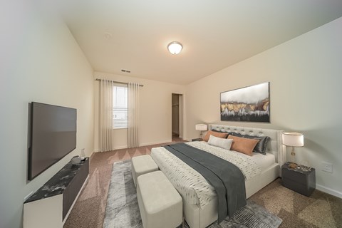 A bedroom with a large bed and a flat screen TV.