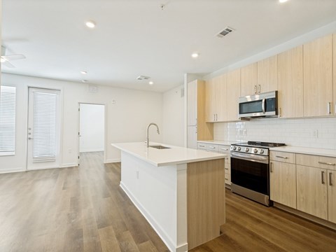 A kitchen with wooden cabinets and a white island.