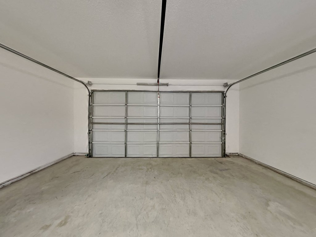 the interior of a garage with a white wall and a garage door