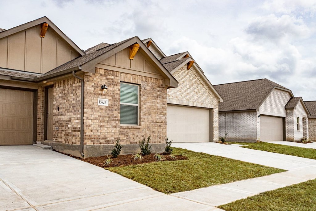 a home with a concrete driveway and two garages