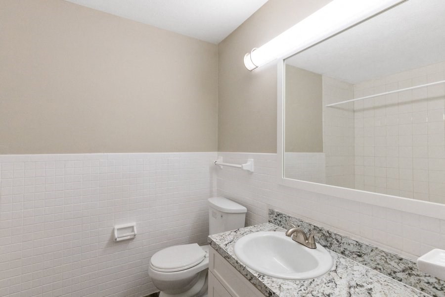 a bathroom with a sink toilet and a mirror