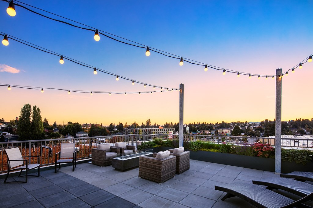 Studios In Greenwood, WA - The Morrow - Outdoor Rooftop Deck With Cozy Seating, Hanging Lights, Beautiful Views, And Fireplace