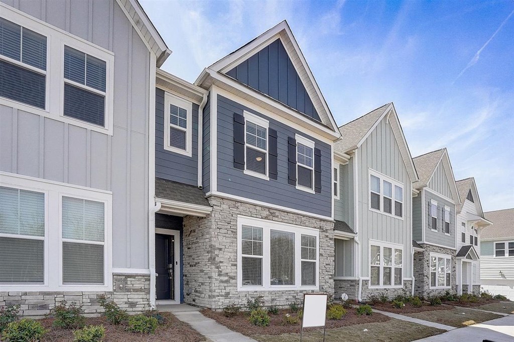 A row of houses with a mix of grey and white siding.