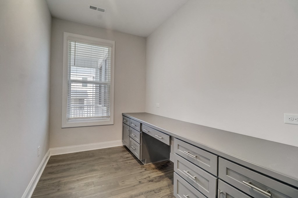 a bedroom with a desk and a window