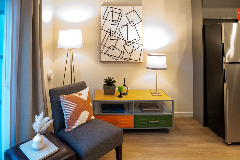 a small living room with a couch and a chair and a table with two lamps