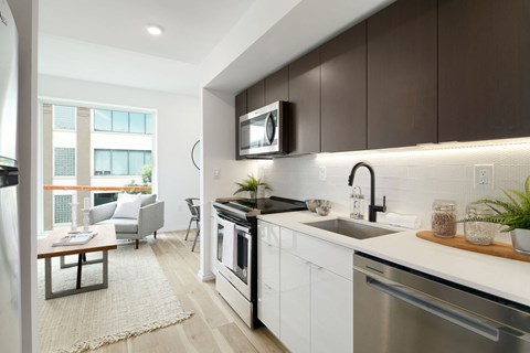 A modern kitchen with dark brown cabinets and stainless steel appliances.
