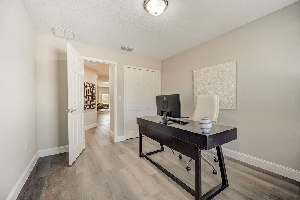 Spacious office area with a desk and chair at The Groves at Lake Ella in Lady Lake, Florida, a pet-friendly rental community.