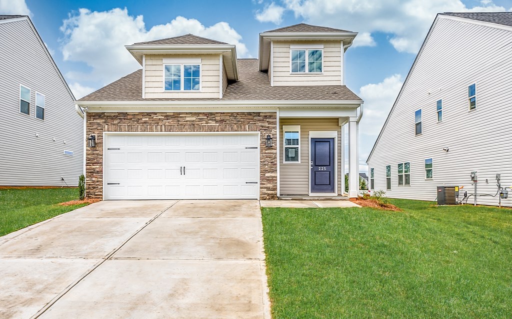 a white house with a white garage door and a lawn